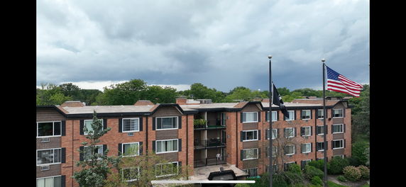 Front view of a multi-story brick building with windows and balconies.