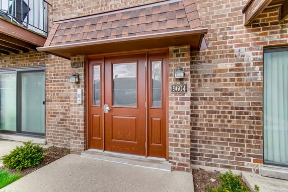 Front view of a brick house with a wooden front door.