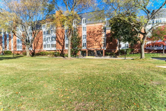 Front view of a multi-story brick building with large windows.