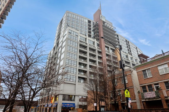 Front view of a multi-story building with large windows and balconies.