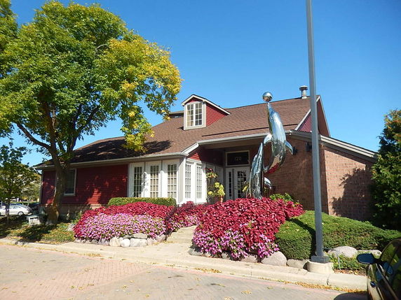 Front view of a house with a brick facade and decorative sculptures.