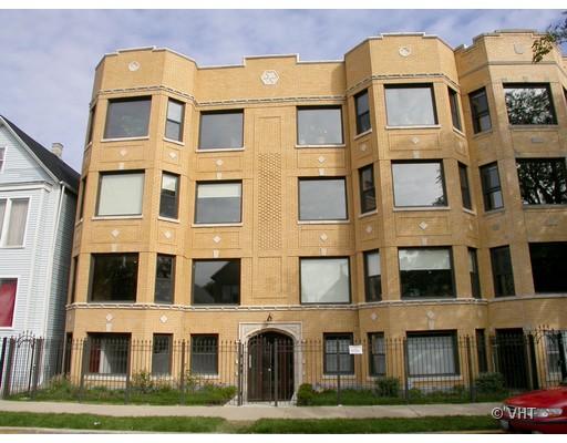 Front view of a multi-story building with large windows and decorative brickwork.