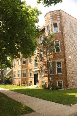 Front view of a multi-story brick building with multiple windows.