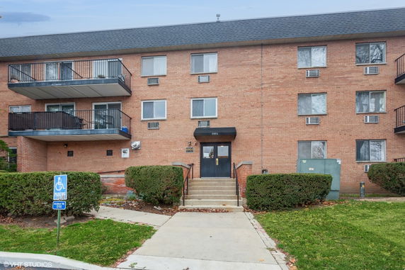 Front view of a multi-story brick building with balconies.