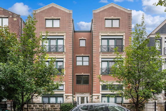 Front view of a multi-story brick apartment building.