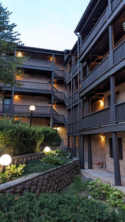 Front view of a multi-story building with balconies and exterior lighting.