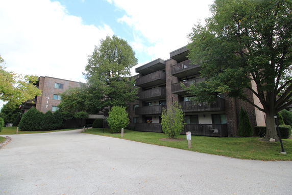 Front view of a multi-story apartment building with balconies.