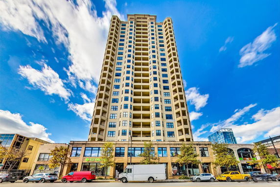 Front view of a tall multi-story residential building with a commercial ground floor.