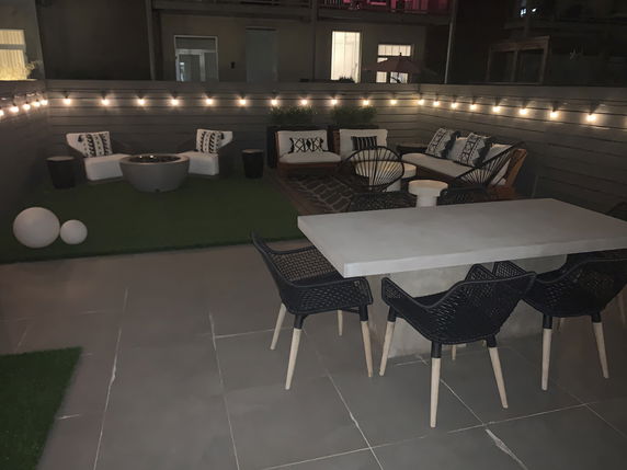 Indoor seating area with a table, chairs, and lounge seating around a fire pit.
