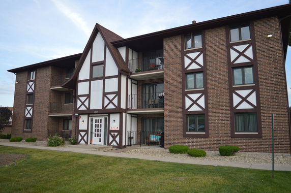 Front view of a multi-story brick building with Tudor-style elements.