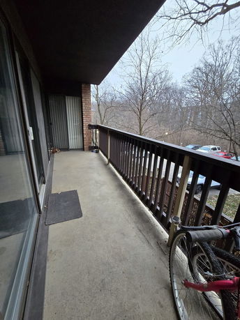 View from a balcony overlooking parked cars and trees