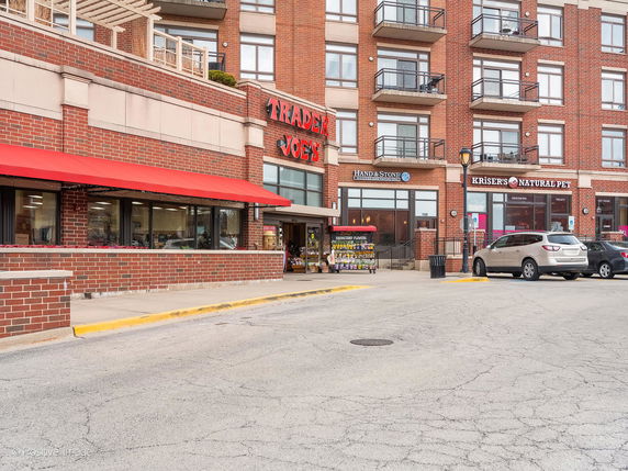 Front view of a multi-story commercial building with various shops.