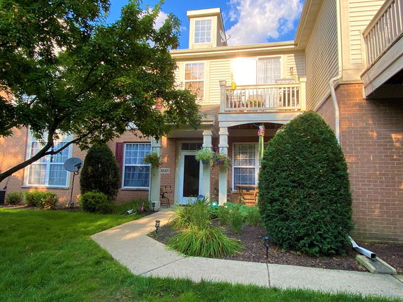 Front view of a two-story house with a small porch and balcony.