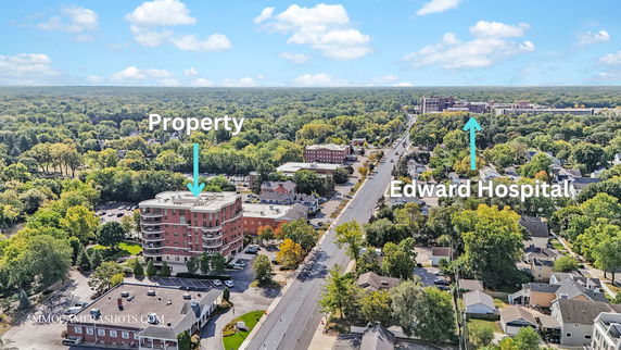 Panoramic view of a suburban area with a multi-story building and nearby hospital.