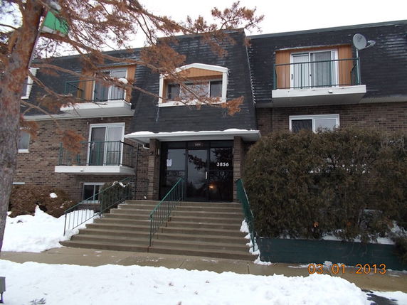 Front view of a multi-story residential building with a central entrance.