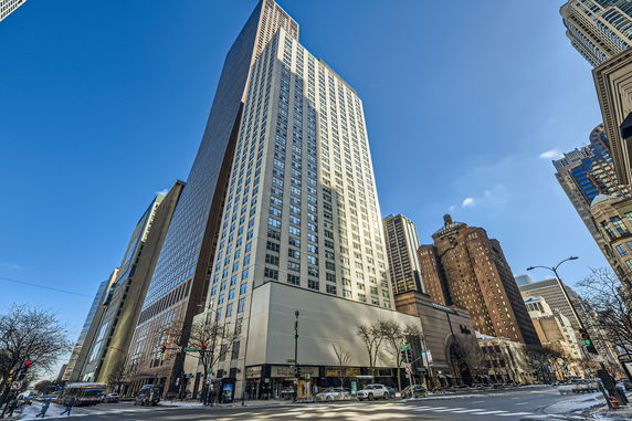 Front view of a tall multi-story building in a cityscape.