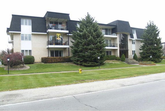 Front view of a multi-story apartment building with balconies.