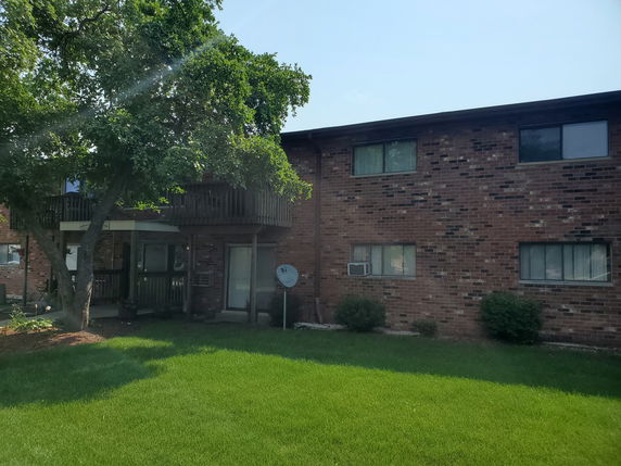 Front view of a two-story brick apartment building with balconies.
