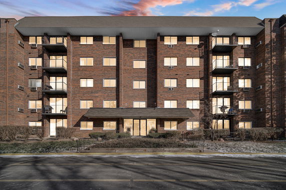 Front view of a multi-story brick building with balconies.
