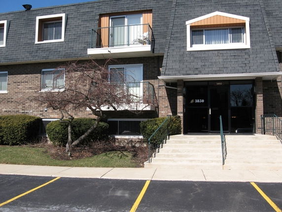 Front view of a multi-story building with a sloped roof and balconies.