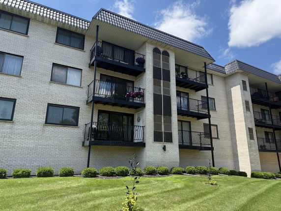Front view of a multi-story apartment building with balconies.