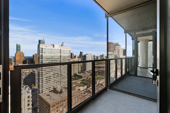 Panoramic view from a balcony overlooking a cityscape with tall buildings.