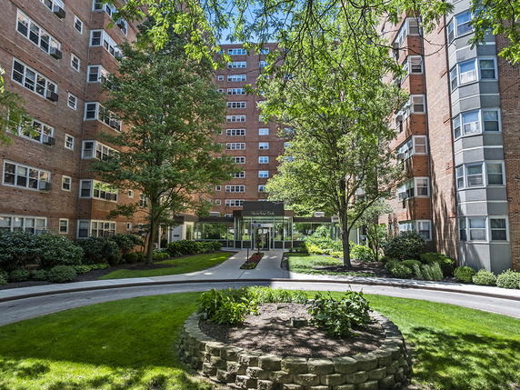 Front view of a multi-story apartment building with a central entrance.
