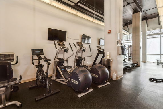 Interior view of a gym with exercise equipment and machines.