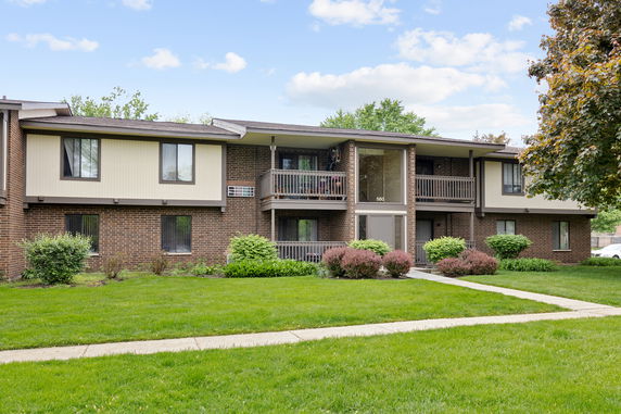 Front view of a two-story apartment building with brick facade and balconies.