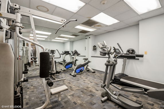 Indoor gym area with exercise equipment such as treadmills and bikes.