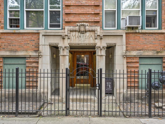 Front view of a brick building with detailed stone entrance.