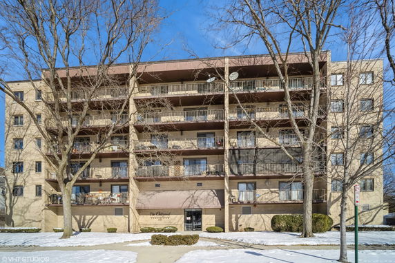 Front view of a multi-story apartment building with balconies.