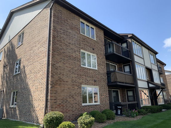 Front view of a multi-story brick building with balconies.