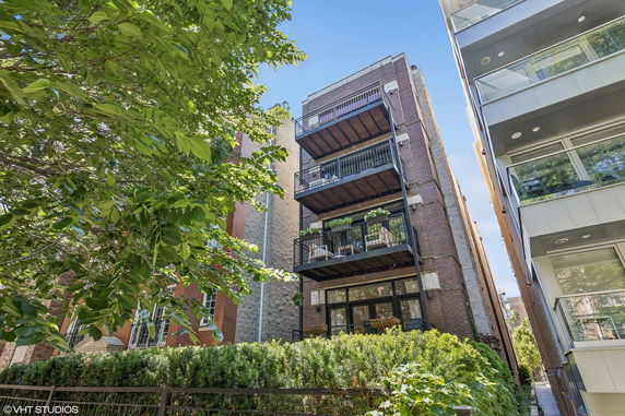 Front view of a multi-story brick building with balconies.
