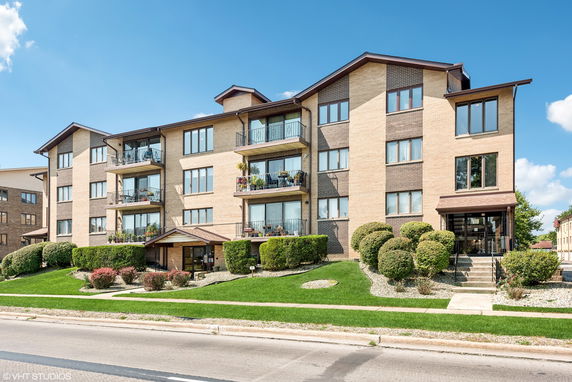 Front view of a multi-story apartment building with balconies.