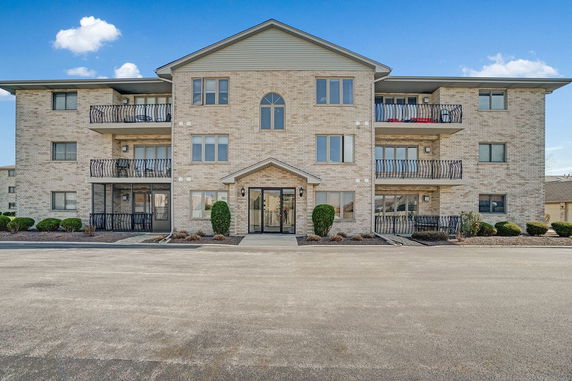 Front view of a three-story apartment building with balconies.