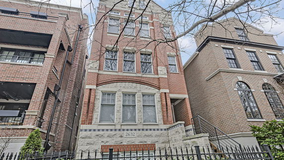 Front view of a multi-story brick building with multiple windows.