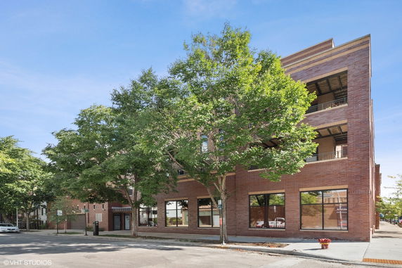 Front view of a multi-story brick building with large windows and balconies.