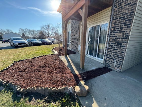 Front view of a house with a patio and brick exterior wall.