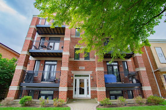 Front view of a multi-story brick building with balconies.