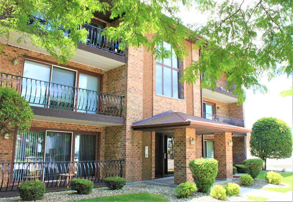 Front view of a multi-story brick building with balconies.