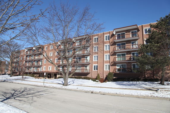 Front view of a multi-story residential building with balconies.