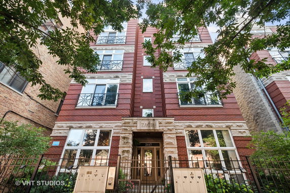 Front view of a multi-story brick building with decorative stone elements.