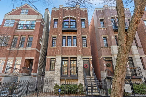 Front view of a multi-story brick building with decorative stonework.