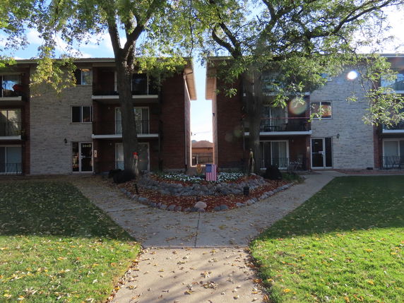 Front view of a multi-story apartment building with balconies.