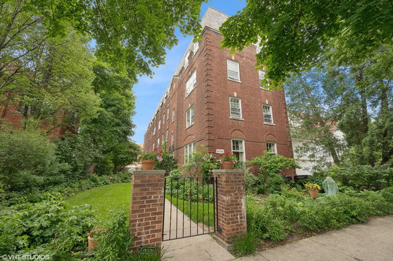 Front view of a multi-story brick building with a garden entrance.