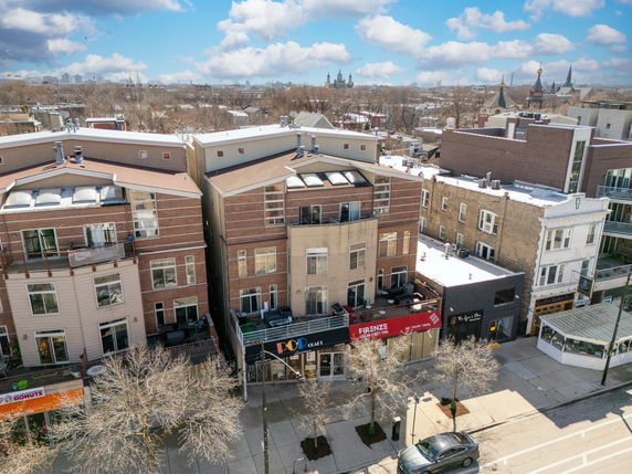 Front view of mixed-use buildings with businesses on the ground floor and residential units above.