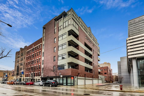Front view of a multi-story brick and concrete building with balconies.