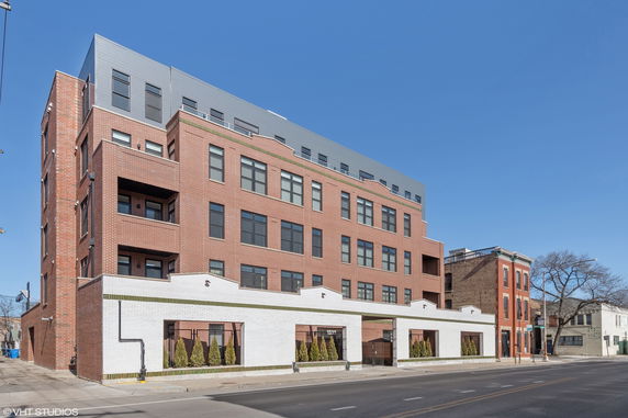 Front view of a multi-story brick apartment building.