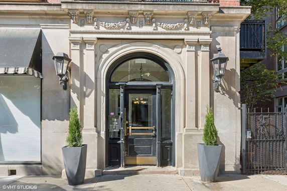 Front view of a building entrance with decorative arch and lanterns.